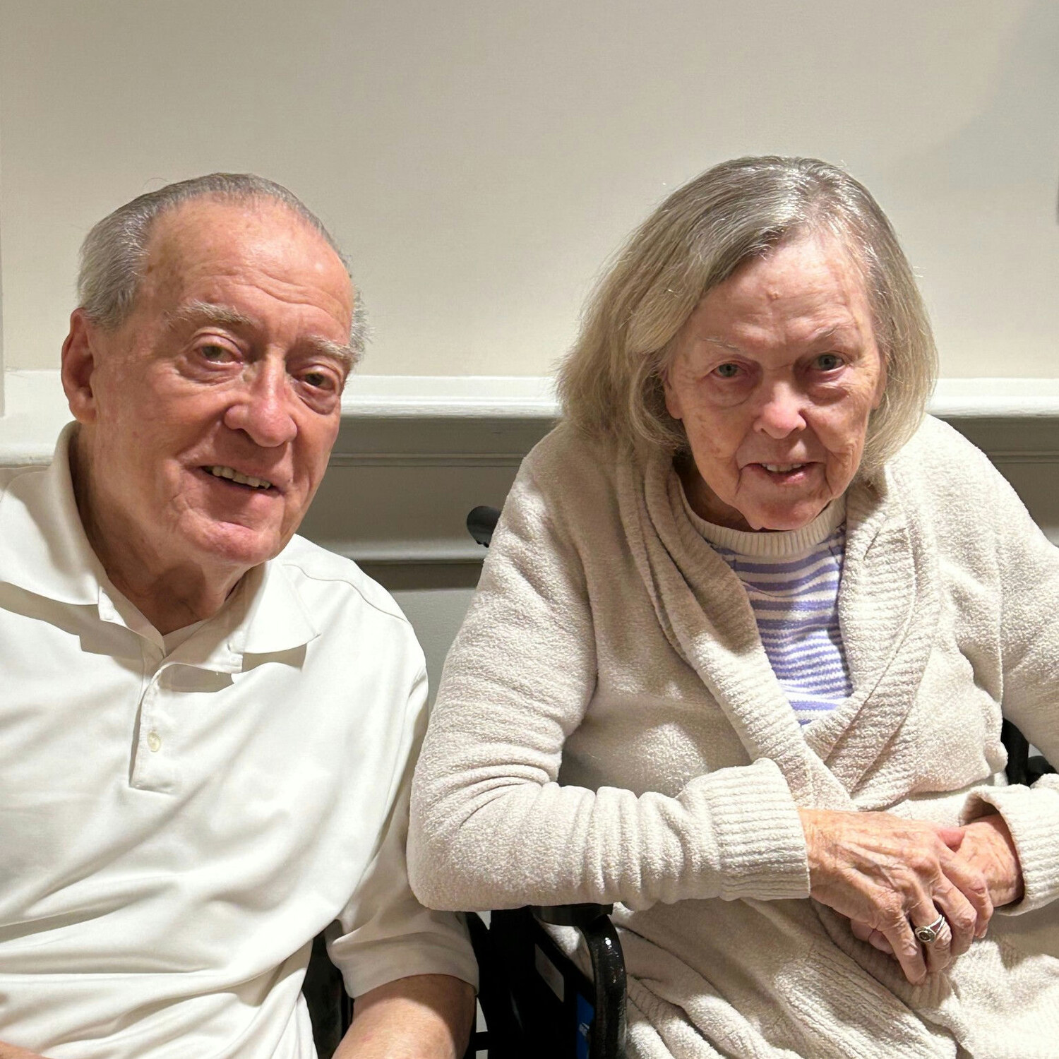 Two residents at Arbor Terrace Norwood share a warm smile together indoors, enjoying a friendly visit at this senior living community in Norwood, NJ.