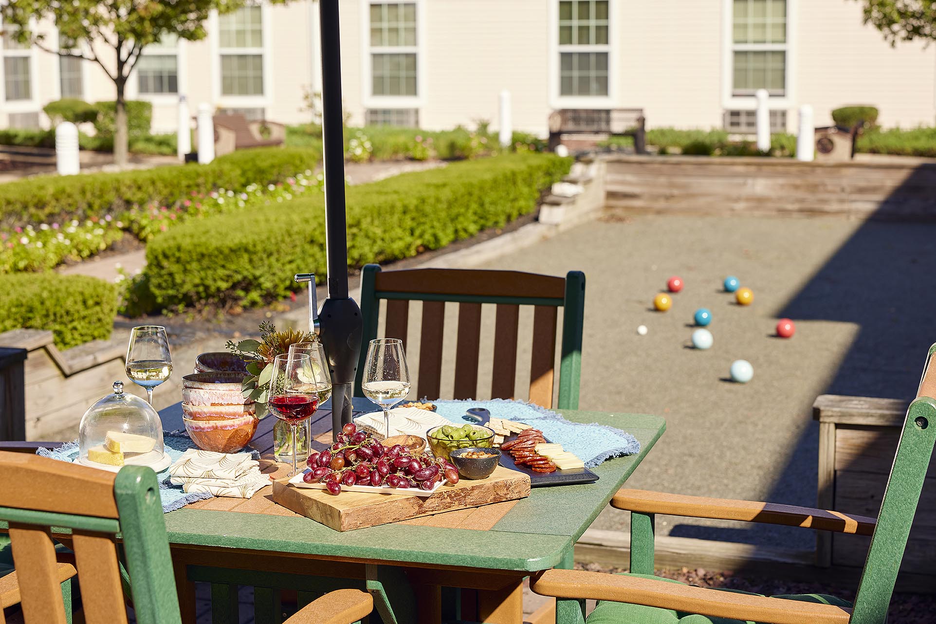 Grapes, cheese and salami with wine next to the bocce court on the patio